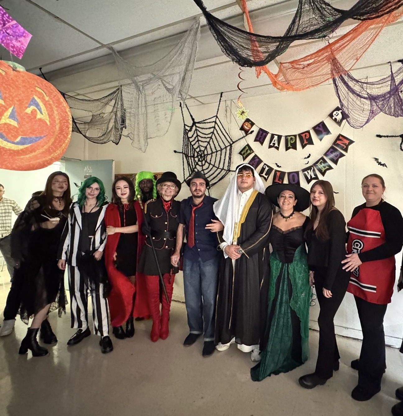 A group of students in Halloween costumes with Halloween decorations in the background