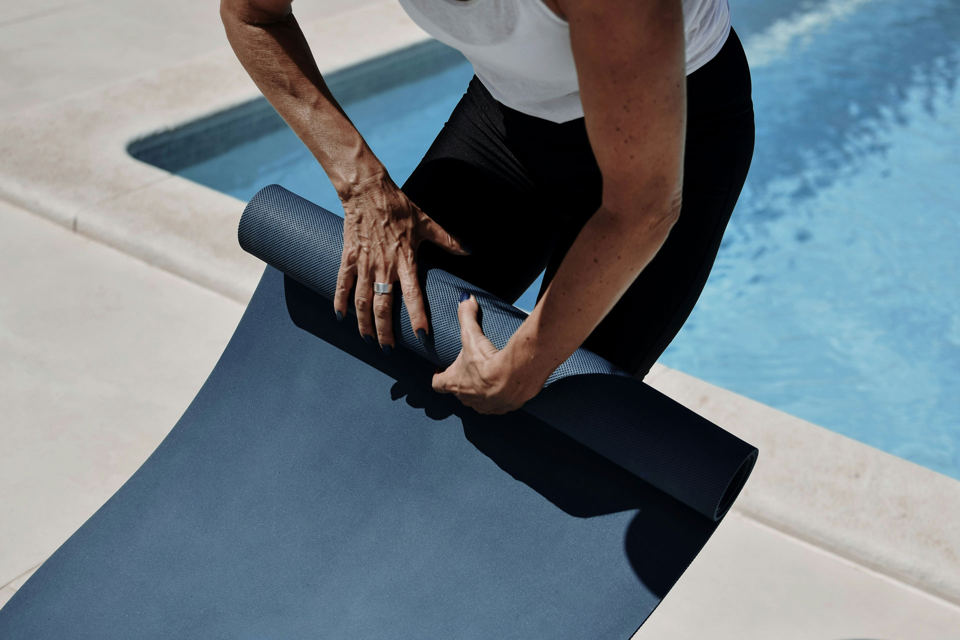 Man rolling up yoga mat