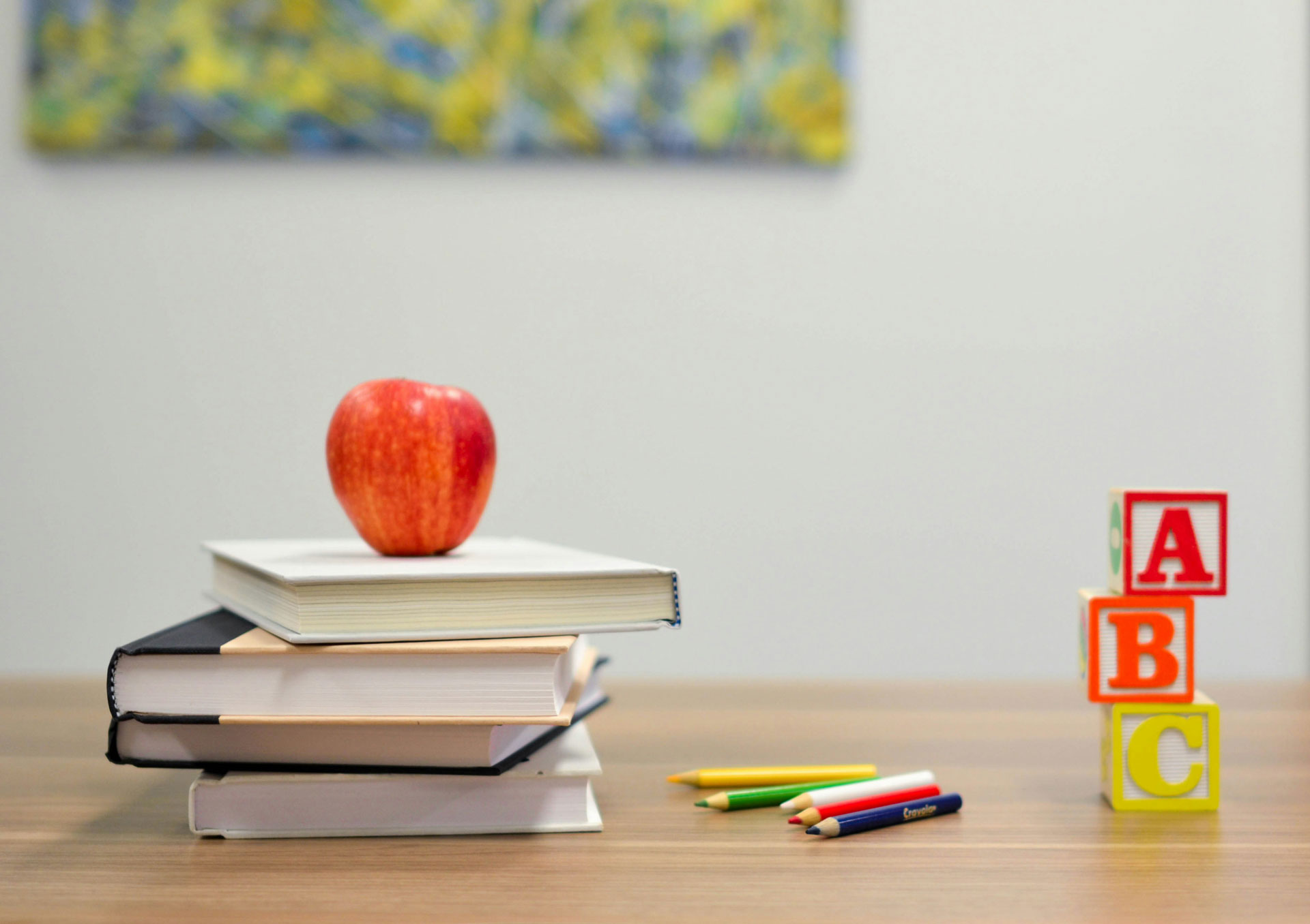 Apple on top of books with letter blocks