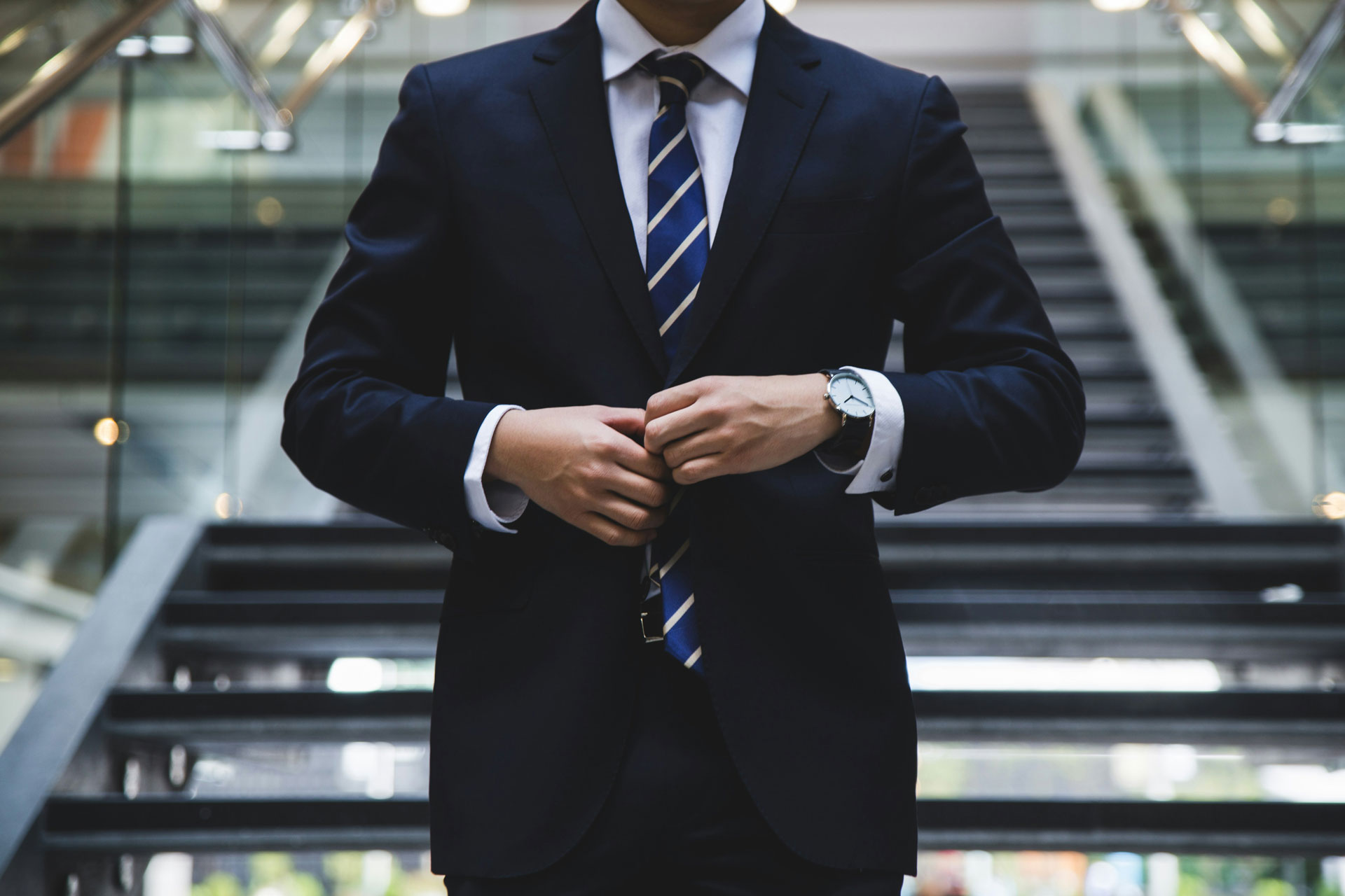 Man in suit and tie buttoning coat