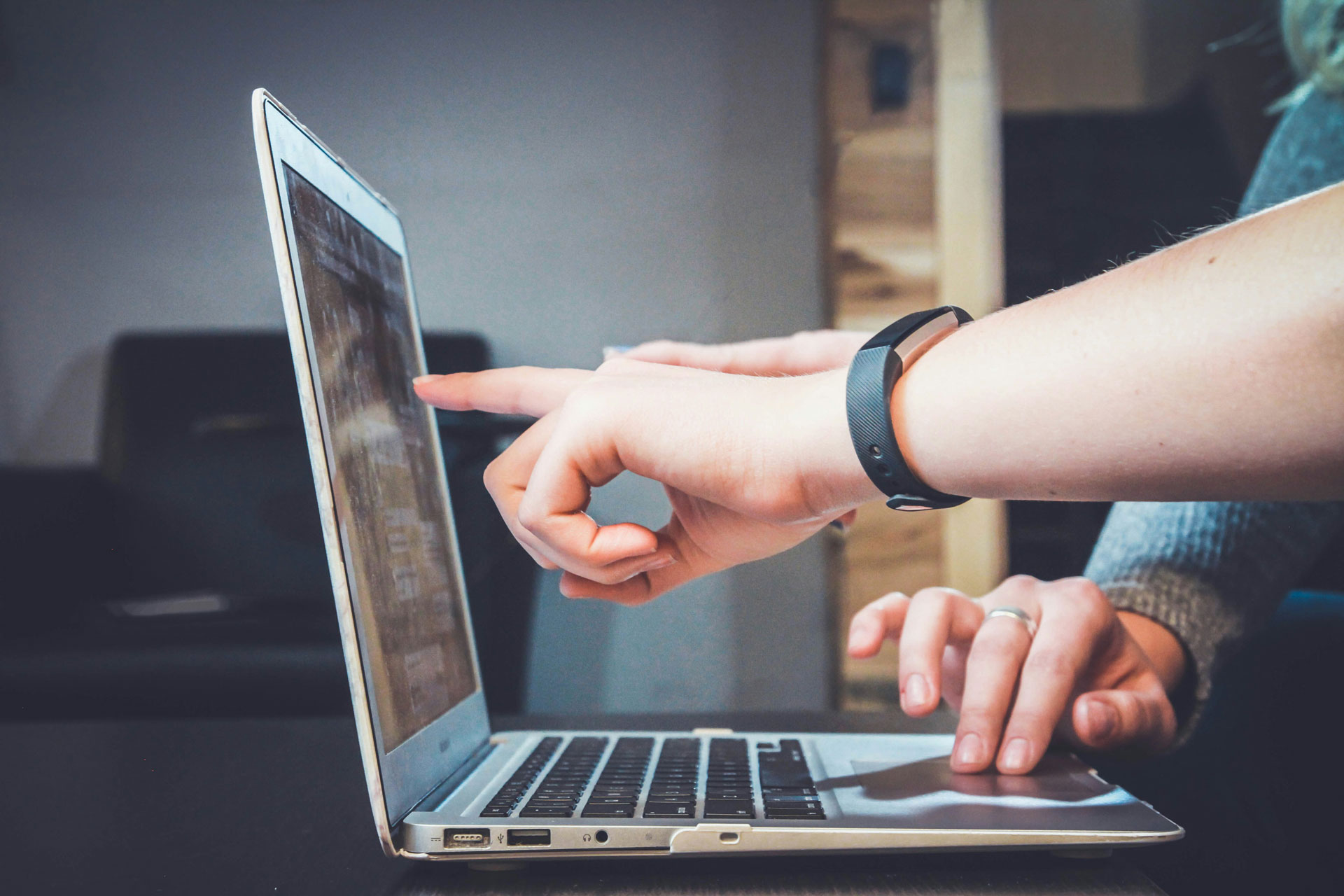 Hand pointing at computer screen
