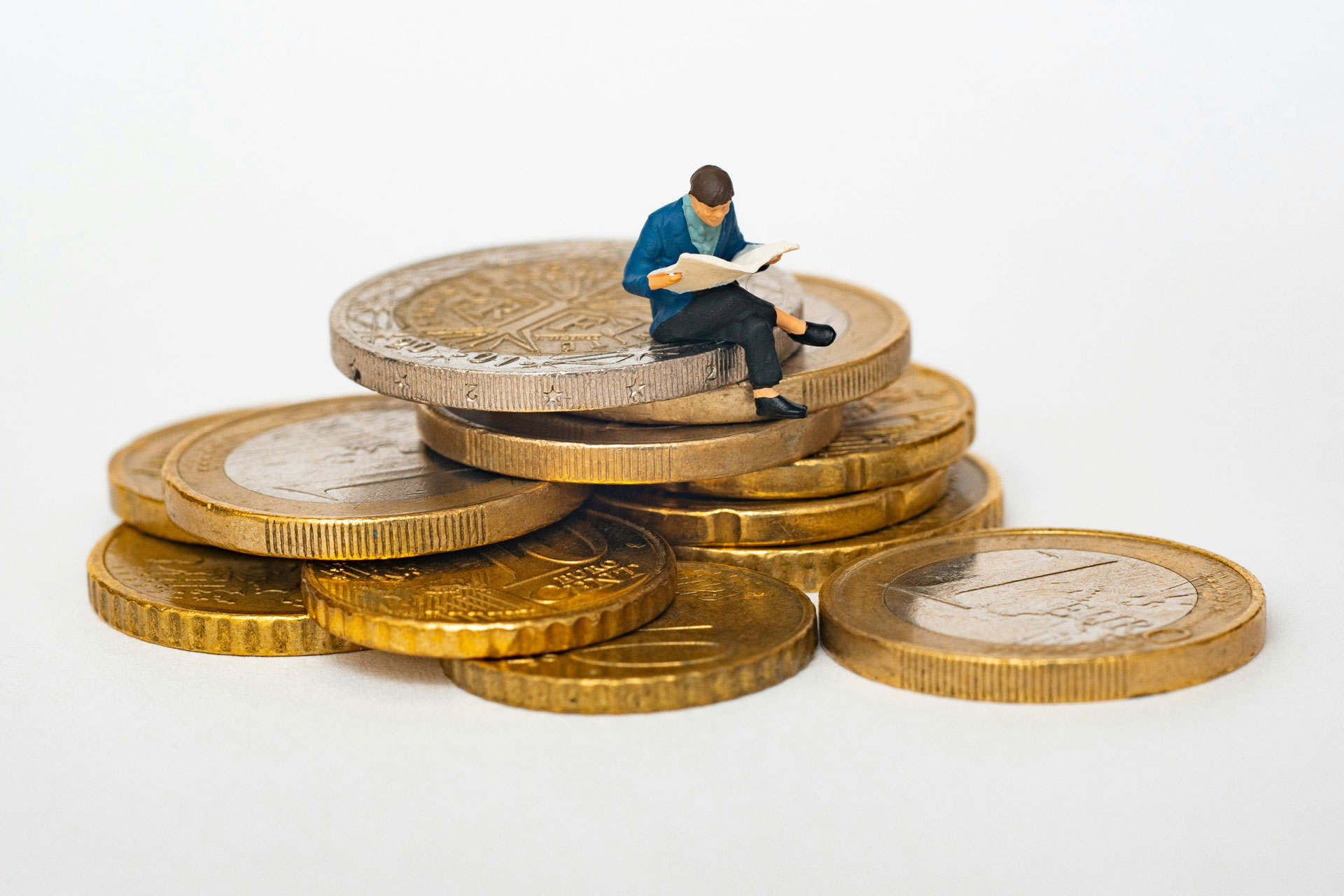 Timy man sitting on coins