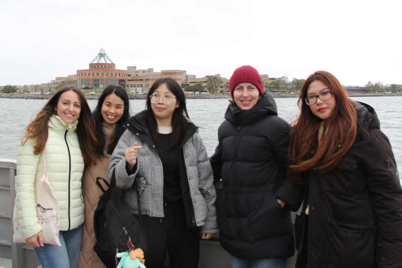 five woman standing by the sea wall