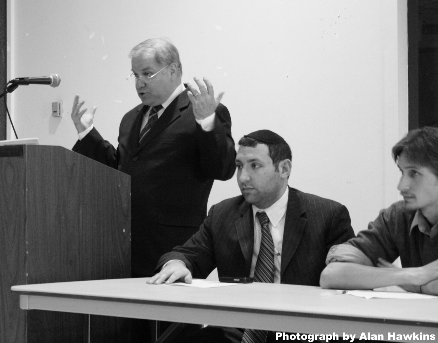 Stephen Cristopher speaks, as Hayon and Webb look on.